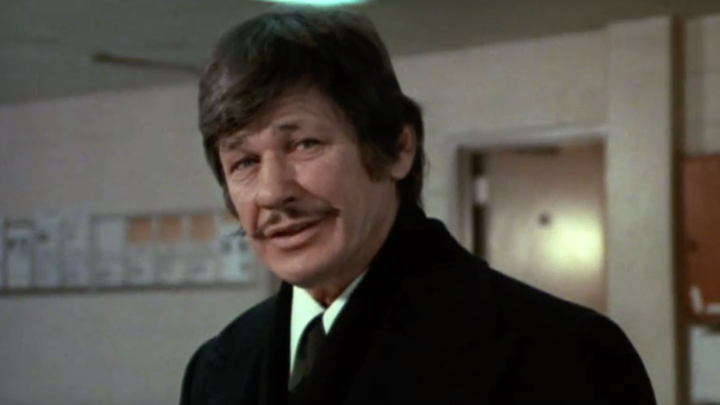 Bruce Willis presenta un mayor elemento socarrón que el original caracterizado por Charles Bronson (en la imagen)